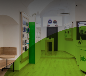 Pohled do interiéru moderní prodejny jabkolevne.cz v Praze s vystavenými produkty, s textem 'Navštivte nás na prodejně v Praze', otevírací dobou 'Po-Ne: 8:30 - 20:00' a tlačítkem 'Navštívit'.