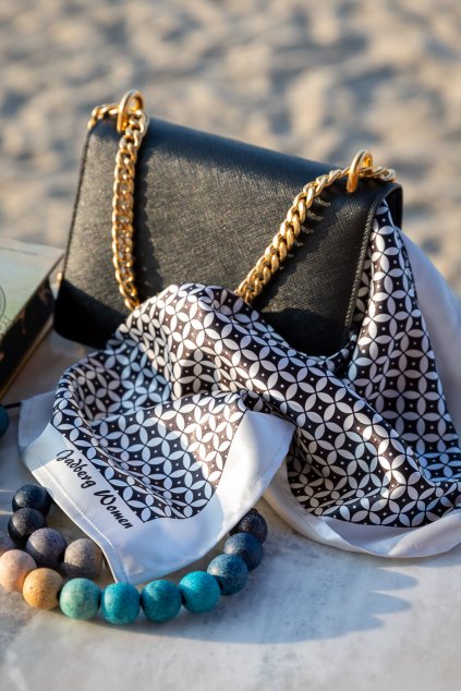 Stylový doplněk Joelle položený na stole vedle kožené kabelky.