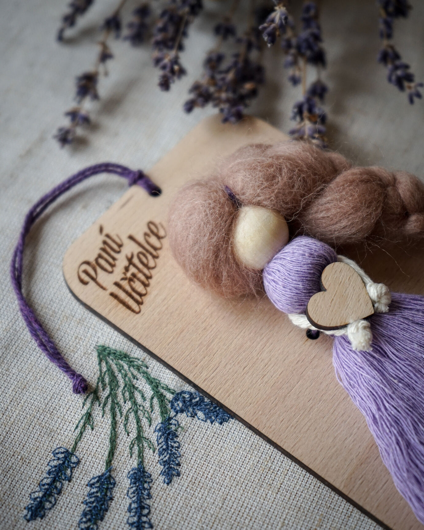 Detail dřevěné hlavičky a účesu fialové macramé panenky