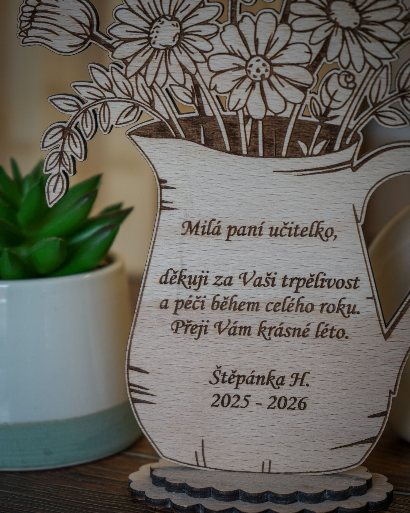 Detail gravírovaného vzkazu na dřevěném džbánku