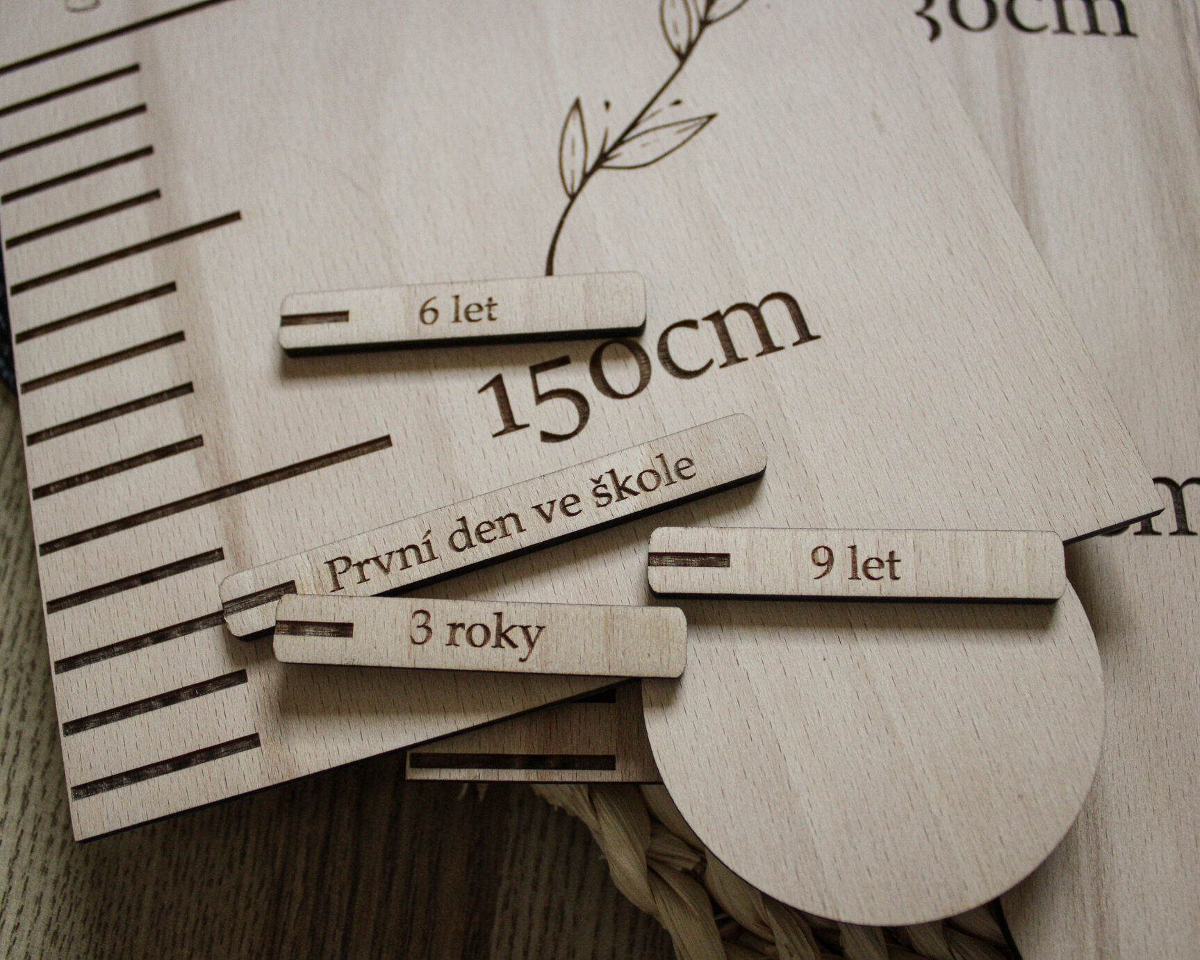 Detail laserového gravírování jména Sofinka a kytičky na dřevěném metru