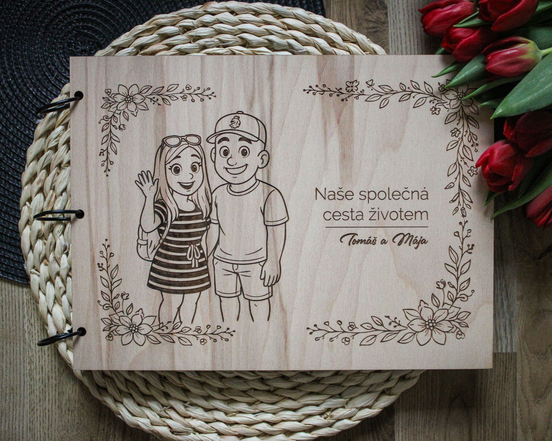 Dřevěné album s karikaturou páru v květinovém věnci