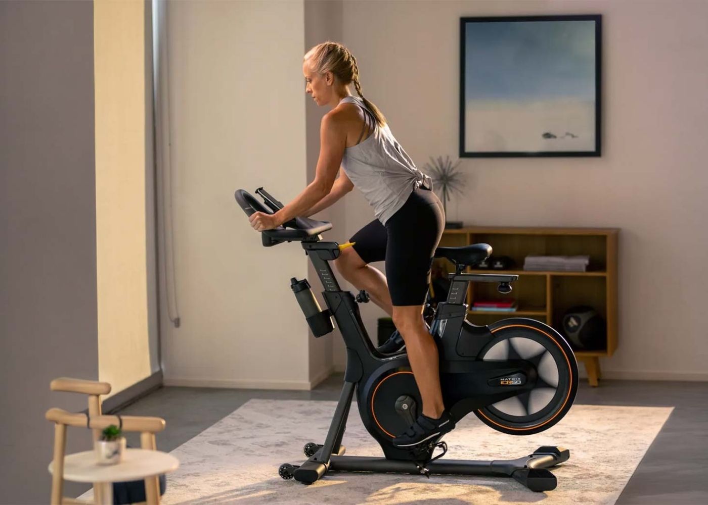 Žena cvičící doma na cyklotrenažéru Matrix ICR50