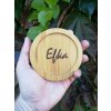 Personalizovaný bambusový podtácek s gravírovaným jménem Efka držený proti pozadí se zelenými listy.