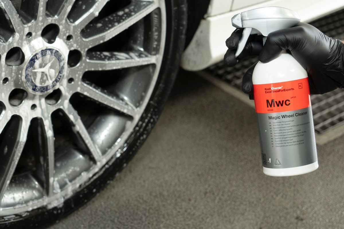 Magic Wheel Cleaner v ruke v čiernej nitrilovej rukavici vedľa disku ošetreného čističom.