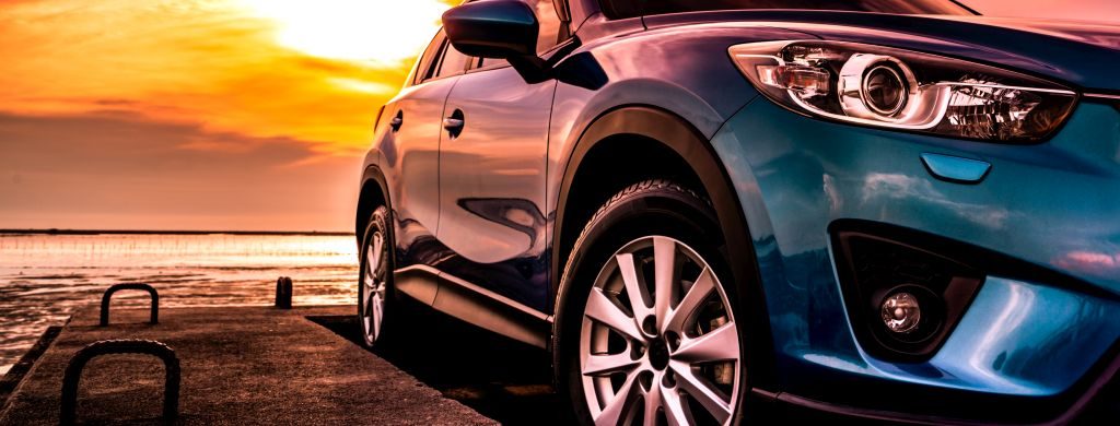 hybridné auto zaparkované pri západe slnka
