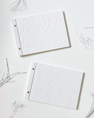 Dvě fotoalba s obálkou z bavlněné lepenky, která je tak nadýchaná, že se do ní rostlinný štoček obtiskával skoro bez...