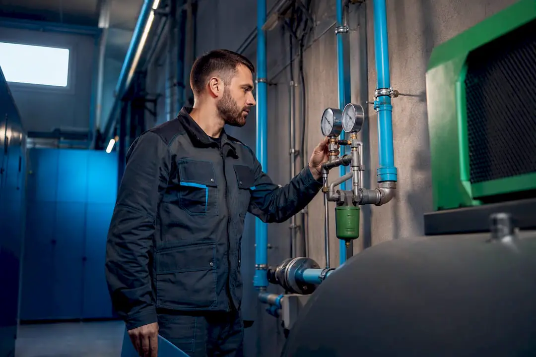 Technik sleduje stav tlakoměrů v technické místnosti