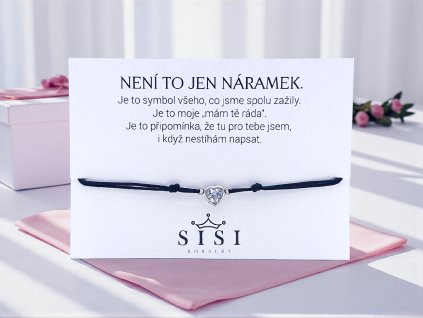Černý provázkový náramek s přívěskem ve tvaru srdce z chirurgické oceli a čirým krystalem, položený na dárkové kartičce s osobním vzkazem. Korálky Sisi