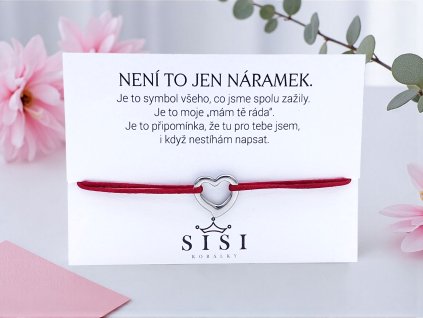 Provázkový náramek se srdcem z chirurgické oceli na tmavě červené saténové šňůrce, položený na dárkové kartičce se vzkazem.