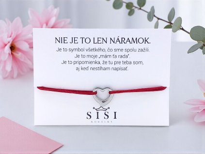 Provázkový náramok so srdcom z chirurgickej ocele na tmavočervenej saténovej šnúrke, položený na darčekovej kartičke s odkazom.