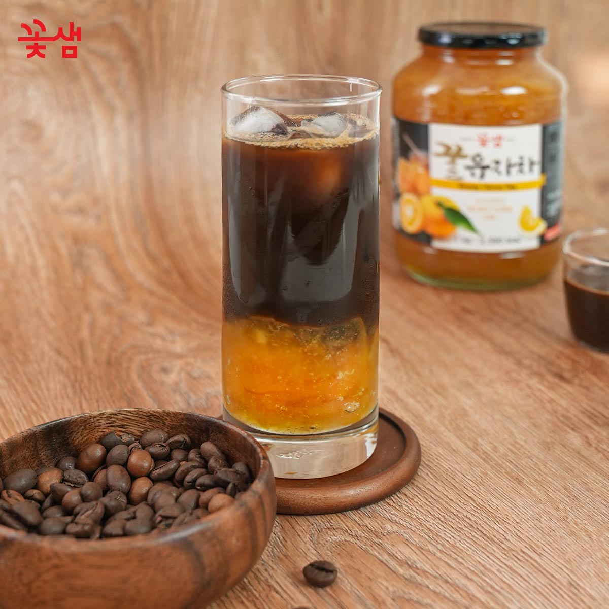 Yuzu Espresso Tonic – trendy nápoj připravený z espressa, toniku a yuzu čaje Kotsam, s čerstvými kávovými zrny na dřevěném pozadí