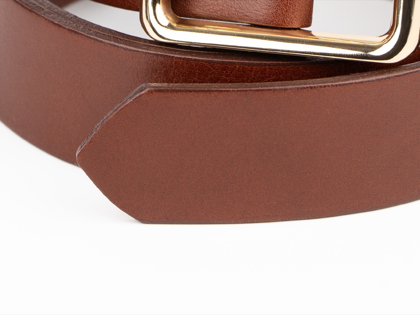 Makro hnědé hladké hovězí kůže opasku Amelia — povrch bez prošití, zabarvená hrana a našikmo seříznutý konec