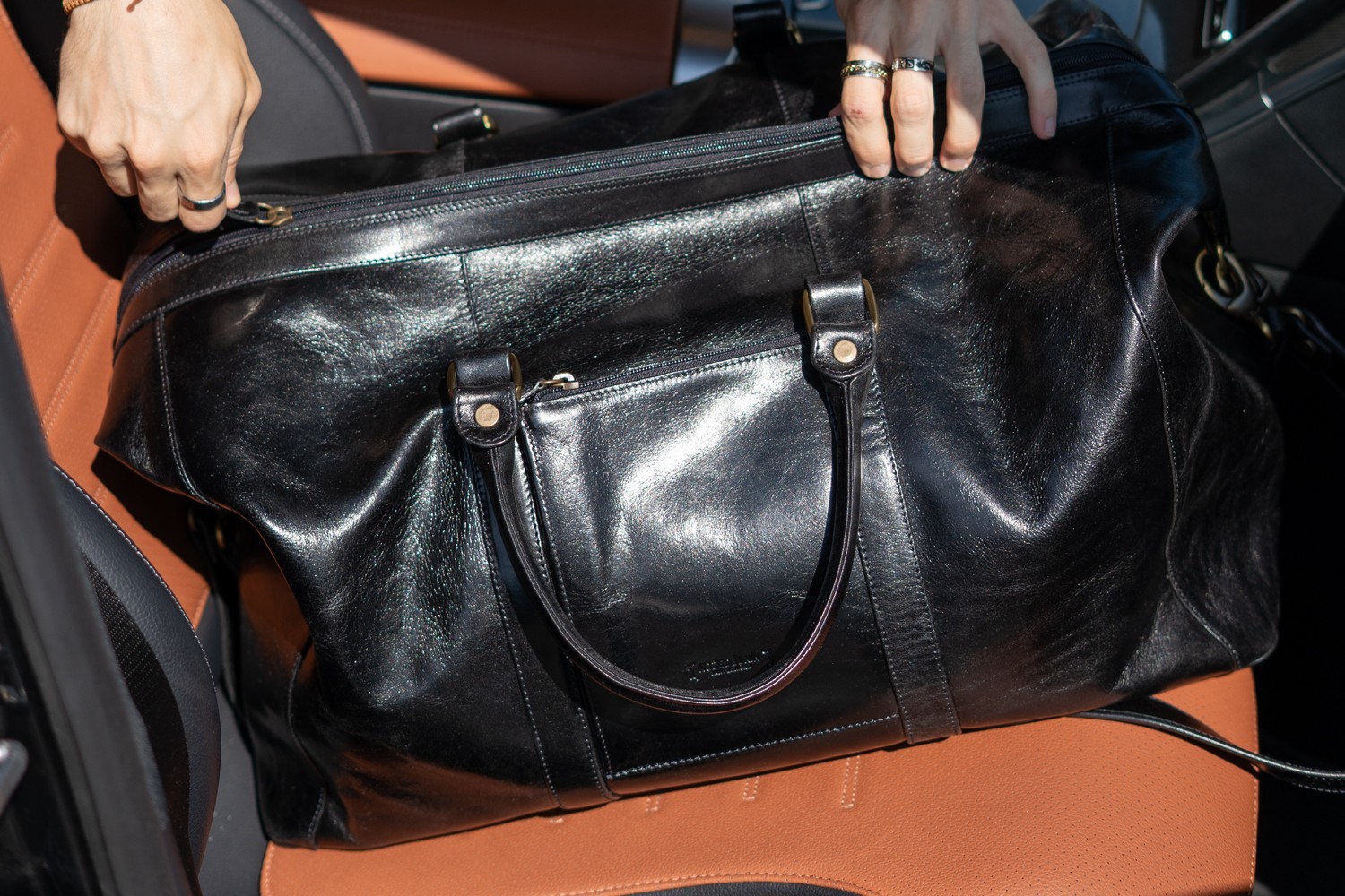 Detail přední kapsy na zip černé tašky Marco
