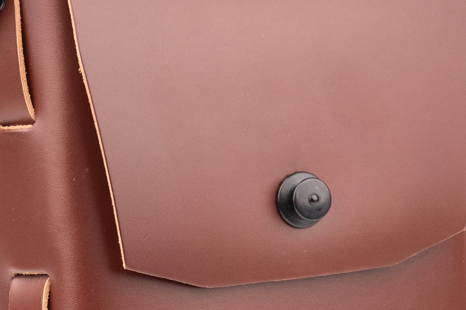 Detail víka hnědé brašny Messenger 2.0 s černým zámkem Loxx a světlými řezanými hranami