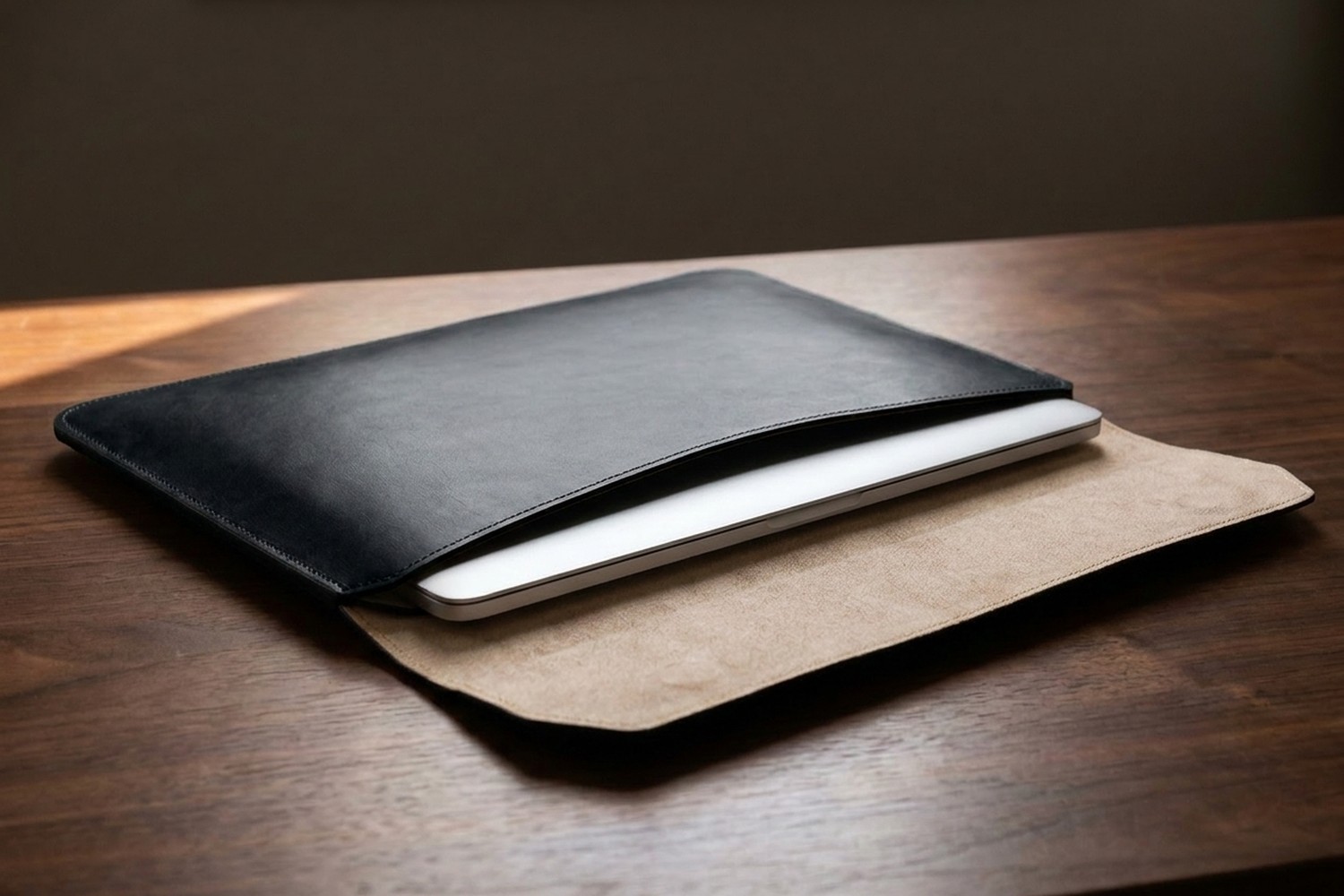 Otevřené černé pouzdro na ořechovém stole, uvnitř béžové italské mikrovlákno a zasunutý notebook 15″
