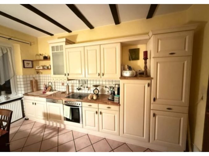 Krásná krémová venkovská kuchyně s vestavěnými spotřebiči