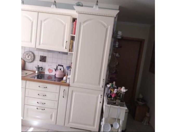 Venkovská krémová kuchyně s vestavěnými spotřebiči a keramickým dřezem