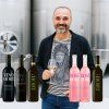 20250623 1436 winemaker and bottles display remix 01jyecg4hsfnjvp9mwvzerhgxt