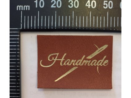 Štítek se zlatým písmem Handmade s jehlou