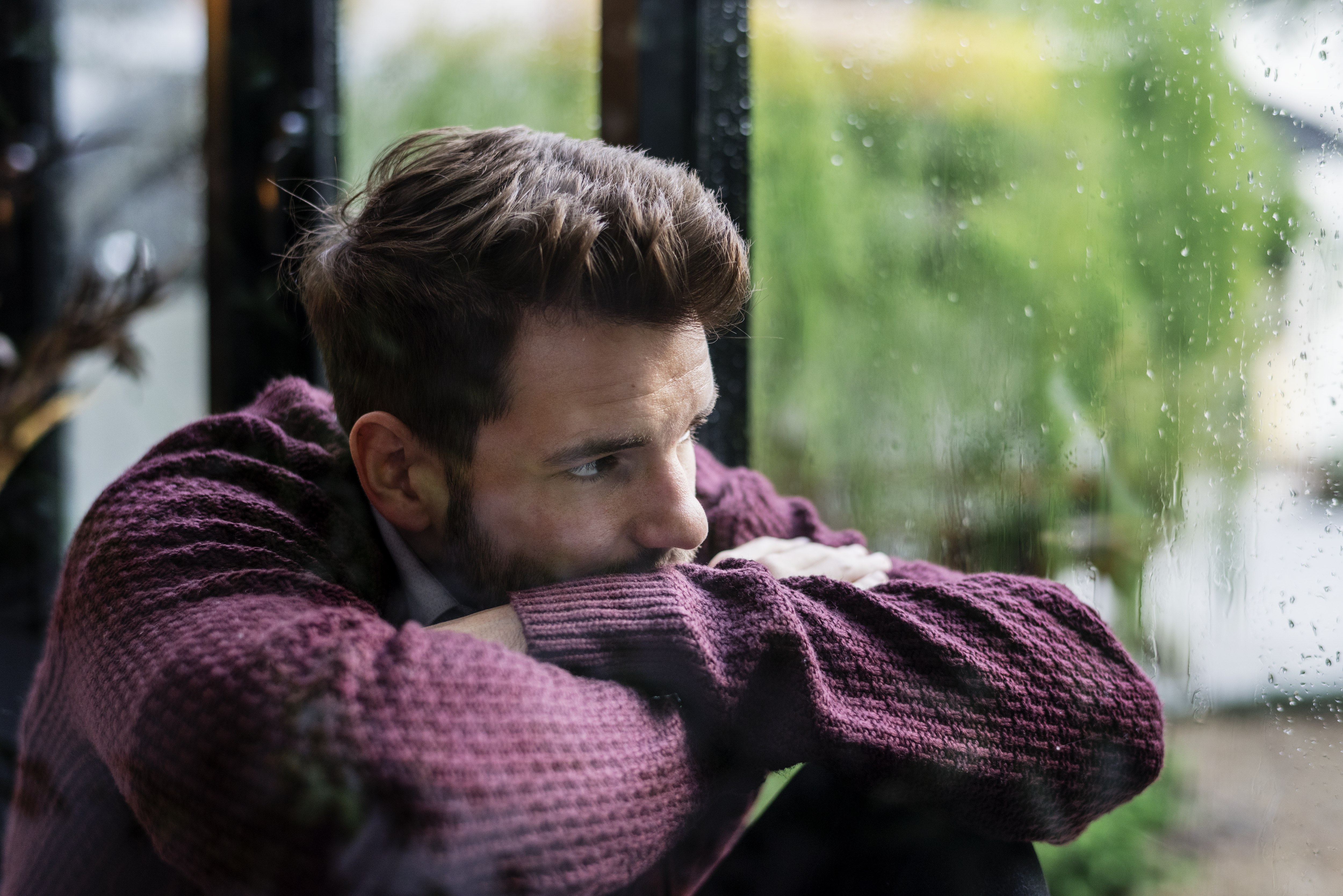 thoughtful-man-looking-out-window