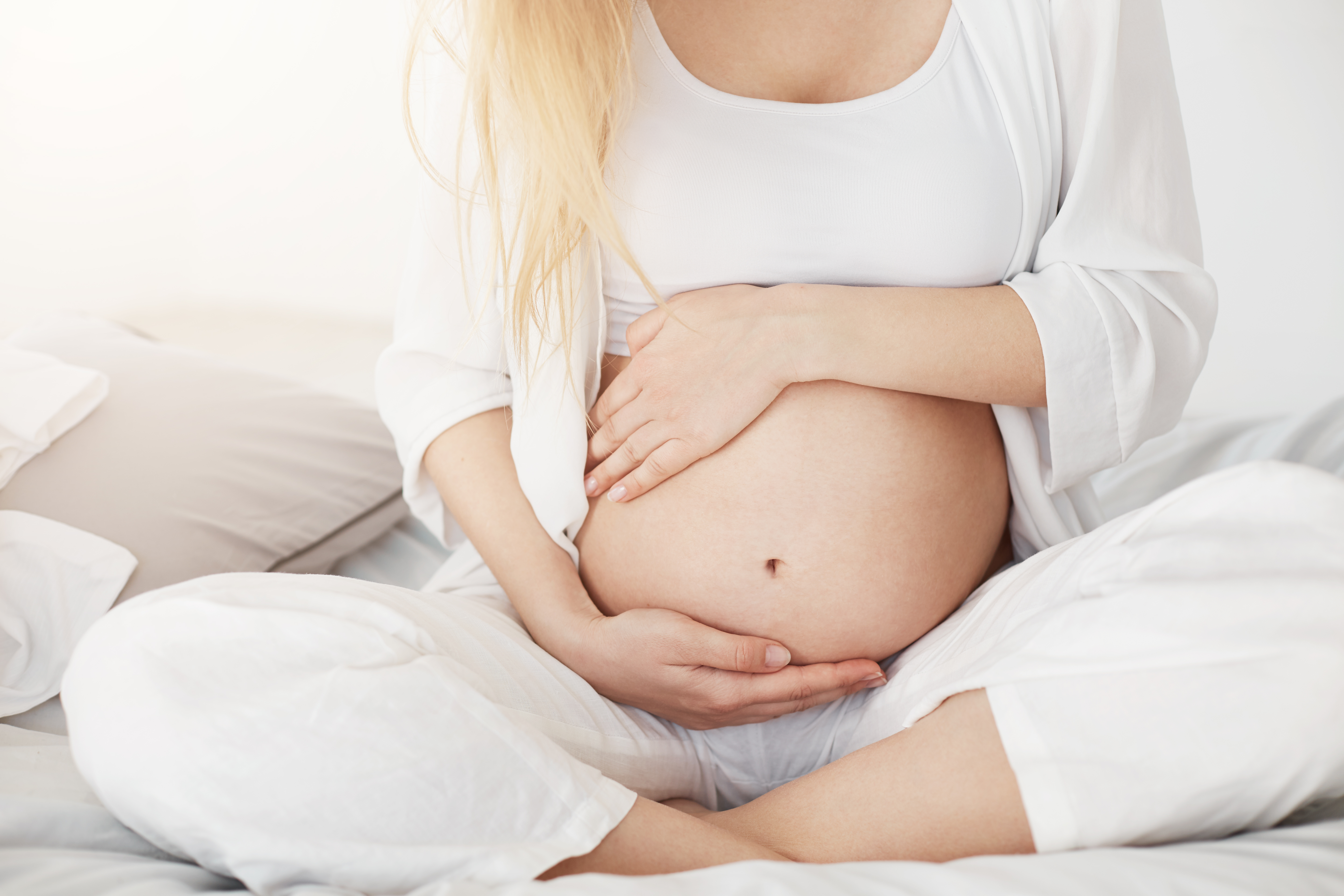 young-pregnant-soon-be-mother-touching-her-belly-sitting-her-bedroom-afternoon-pregnancy-concept