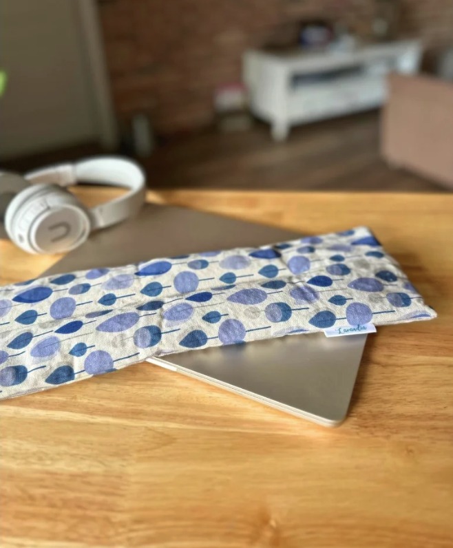 Pánský Krkohřej položený na notebooku vedle sluchátek
