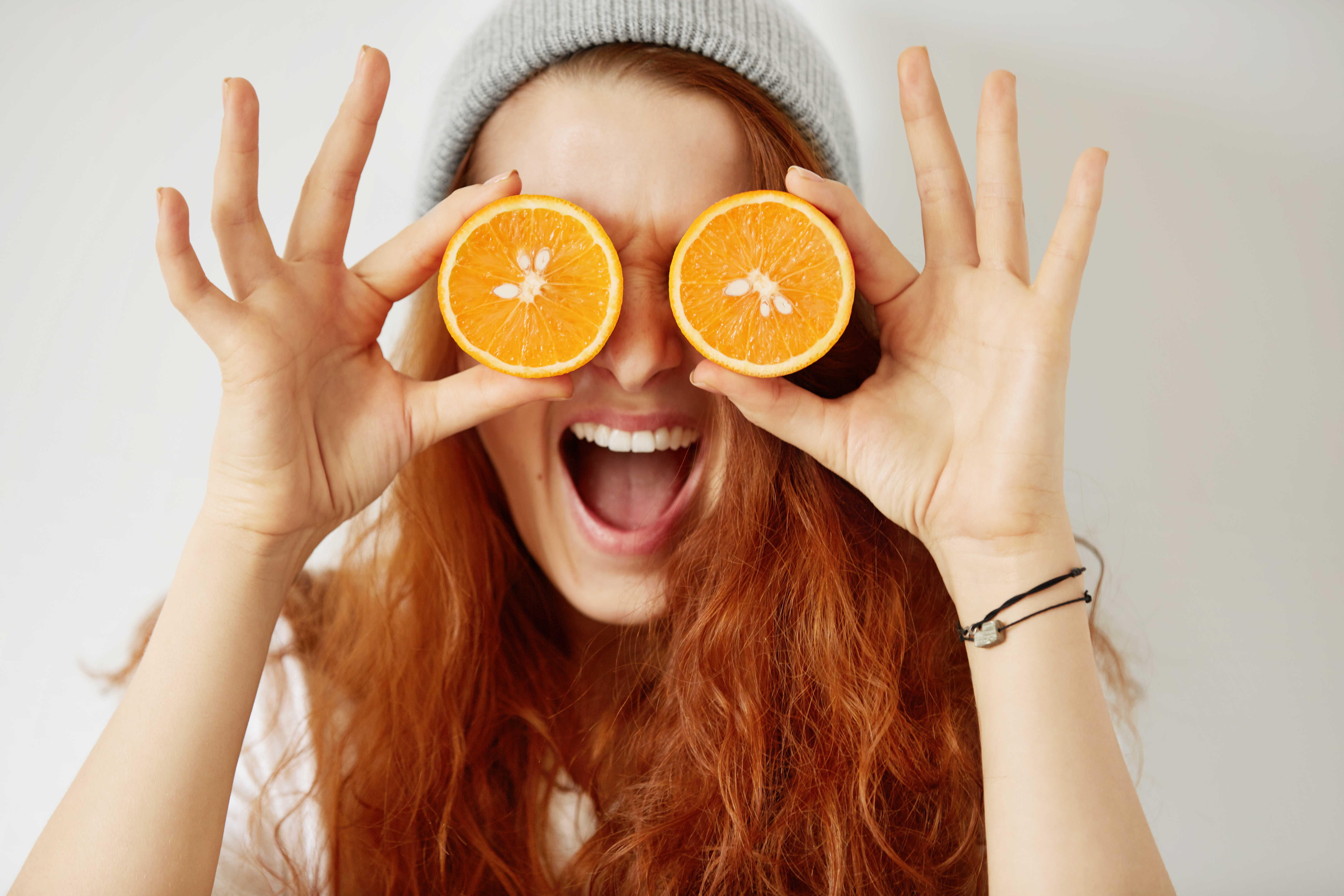 close-up-isolated-portrait-young-redhead-woman-holding-halved-oranges-her-eyes_optimized