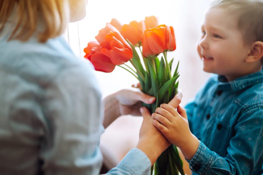 Chlapček dáva mame kyticu tulipánov