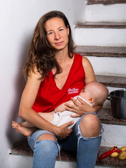 Žena kojí své dítě v červeném tílku Little Hustler