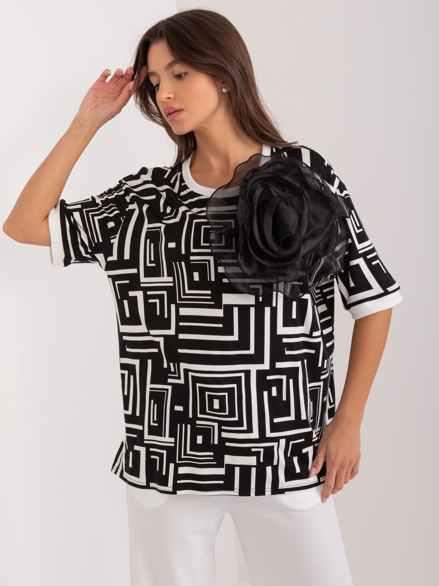 Čierno-biela elegantná blúzka s geometrickým vzorom a kvetinovou brošňou LK-BZ-509697.27-black Veľkosť: ONE SIZE