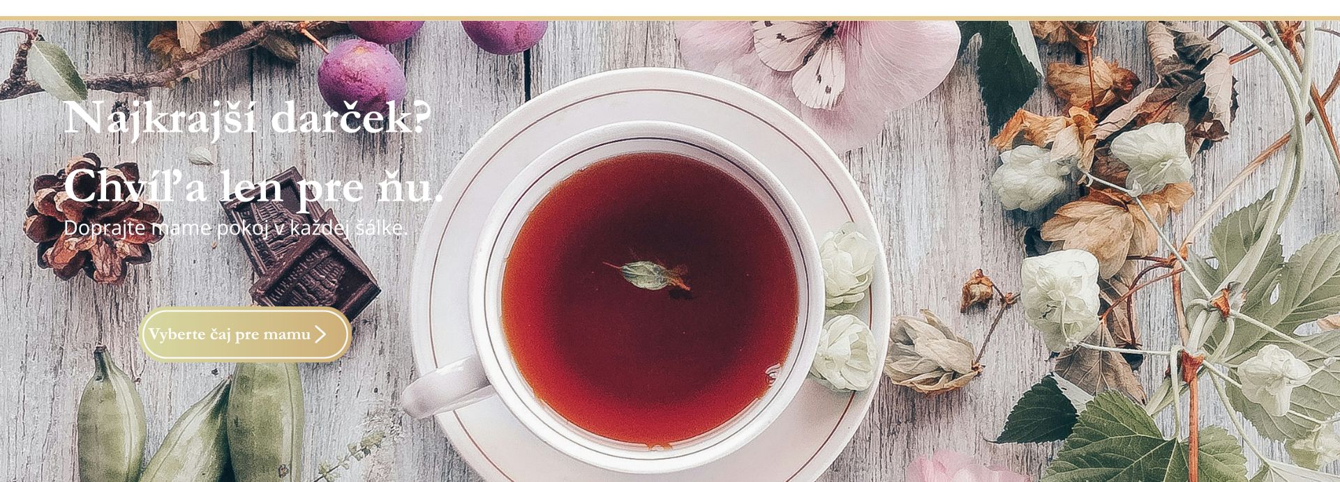 Šálka čaju s kvetmi na drevenom pozadí – darček ku Dňu matiek