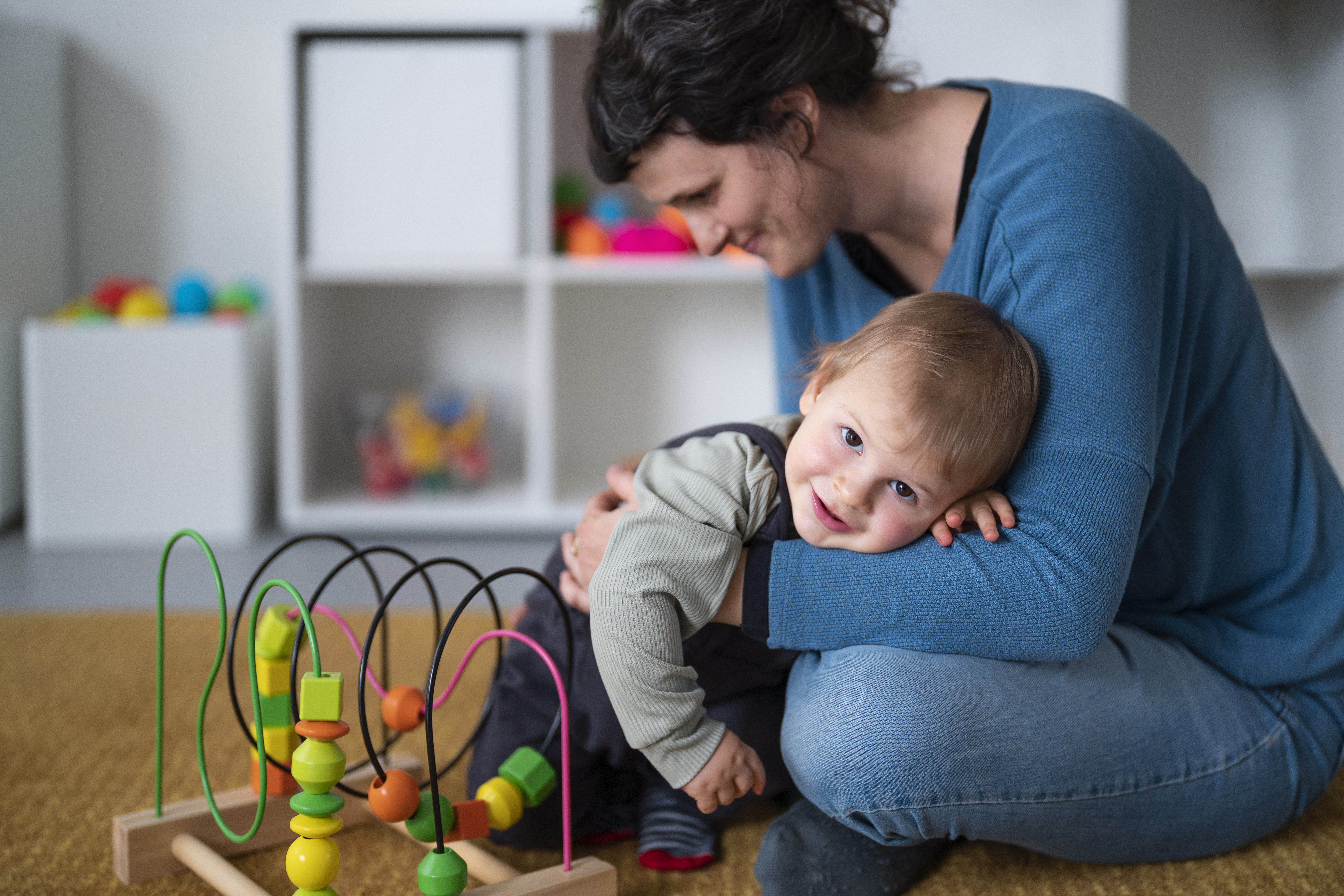 full-shot-smiley-woman-holding-little-kid