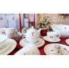 Vánoční jídelní sada Luna Koleda by inspire, s čajovou konvicí a šálky na červeném ubruse.