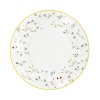Mělký porcelánový talíř Linea Botanic ø 27 cm, bílý s jemným lučním květinovým dekorem a žlutým okrajovým lemem.