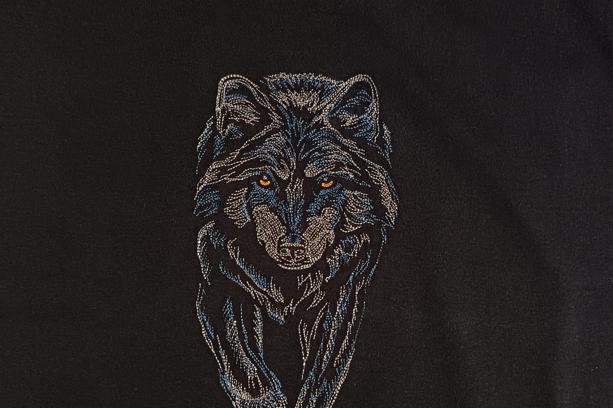 Detail výšivky vlka na čiernom tričku