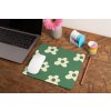 mockup of a mousepad lying on a rustic table next to a flower vase 27554