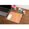 mockup of a mousepad lying on a rustic table next to a flower vase 27554