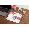 mockup of a mousepad lying on a rustic table next to a flower vase 27554