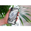 mockup of a woman holding a clear phone case in front of a houseplant 4636 el1 2022 04 26T122141.851