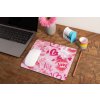 mockup of a mousepad lying on a rustic table next to a flower vase 27554