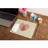 mockup of a mousepad lying on a rustic table next to a flower vase 27554