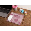 mockup of a mousepad lying on a rustic table next to a flower vase 27554