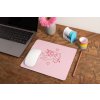 mockup of a mousepad lying on a rustic table next to a flower vase 27554