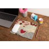 mockup of a mousepad lying on a rustic table next to a flower vase 27554