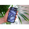 mockup of a woman holding a clear phone case in front of a houseplant 4636 el1 2022 04 26T134259.271
