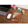 mockup of a mousepad lying on a rustic table next to a flower vase 27554