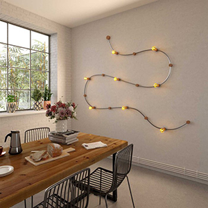 Innen-Lichterkette in Wellenform an der Wand über einem hölzernen Esstisch