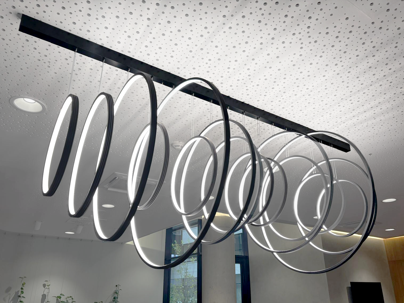 Wygięte w okręgi profile LED jako lampa wisząca w centrum obsługi klientów