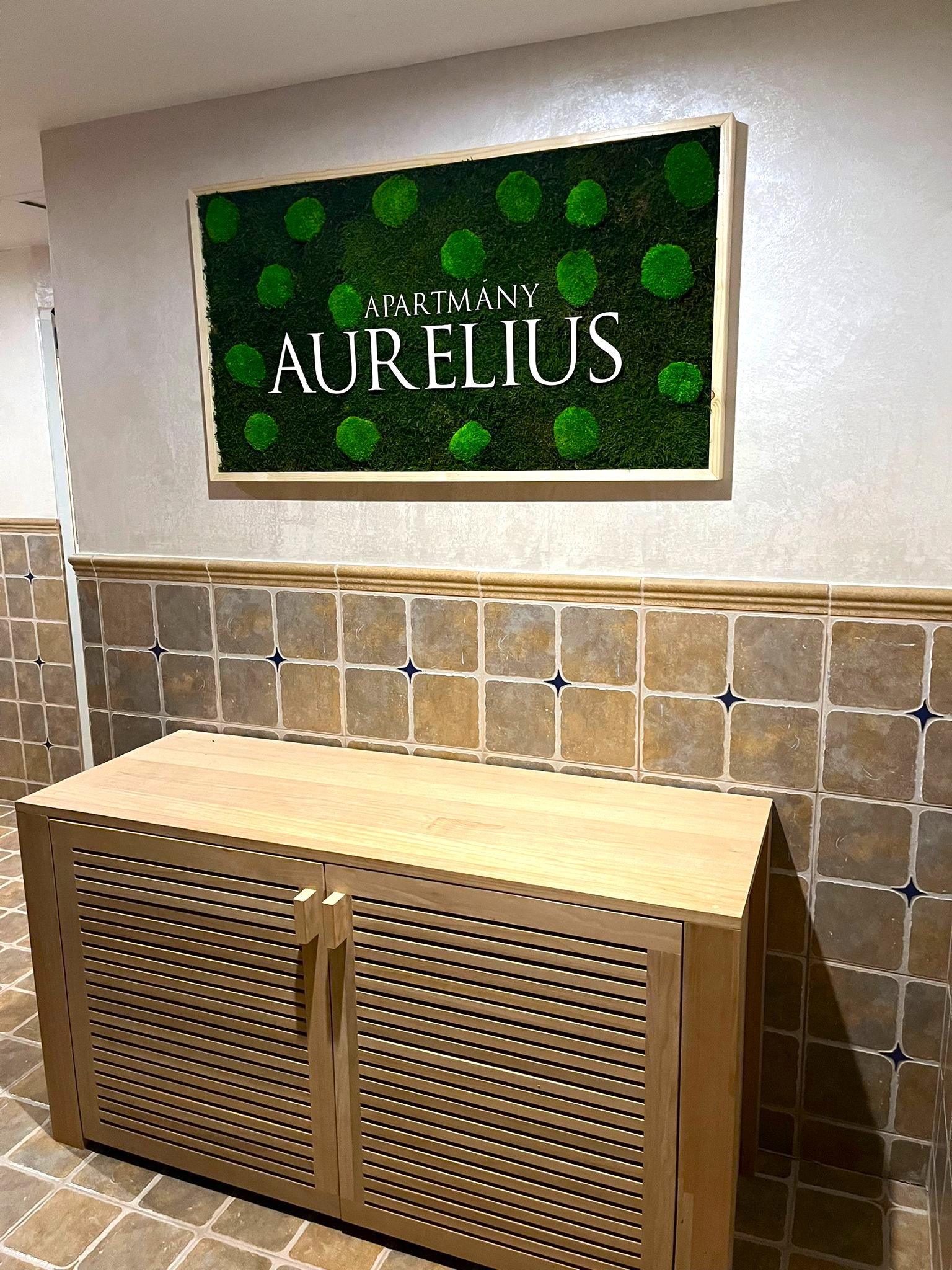 Mechový obraz s dřevěným logem pro Apartmány Aurelius